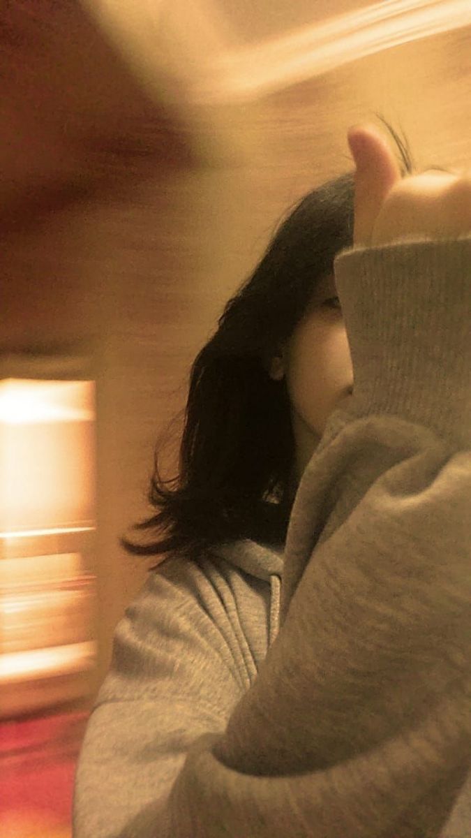 Ảnh gái trẻ mặc áo hoodie xám chụp selfie trong không gian thoải mái