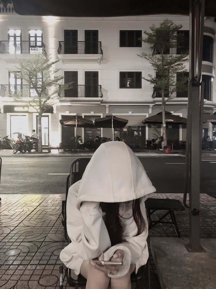 Ảnh gái trẻ mặc áo hoodies trắng ngồi trên ghế