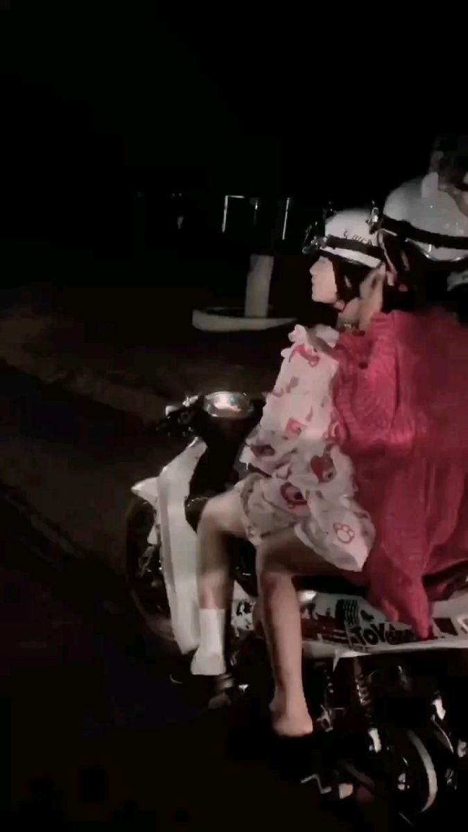 Ảnh gái trẻ mặc áo khoác hồng và váy ngắn trên xe máy