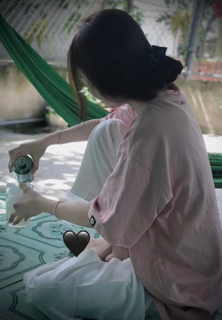 Ảnh gái trẻ mặc áo phông hồng và quần trắng bên cây bóng mát