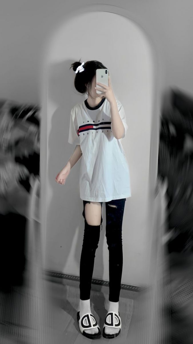 Ảnh gái trẻ mặc áo phông trắng, quần jeans rách đầy phong cách