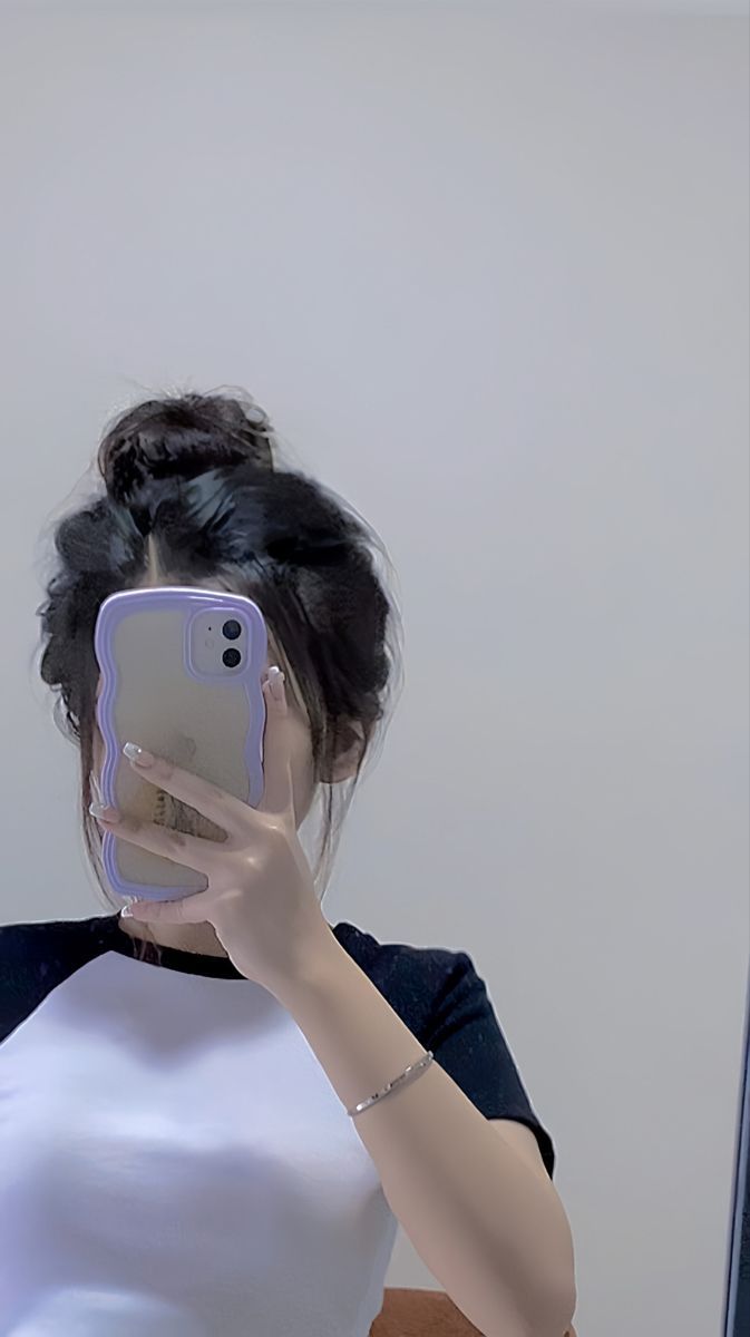 Ảnh gái trẻ mặc áo phông trắng và đen chụp selfie trong phòng