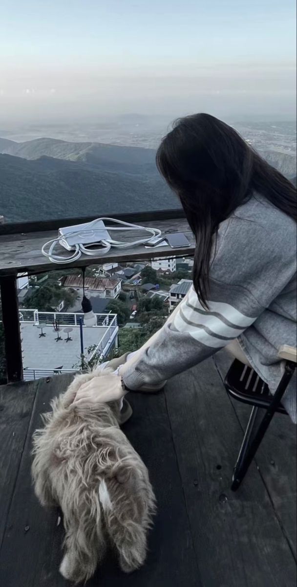 Ảnh gái trẻ mặc áo sweater ngồi bên chú chó