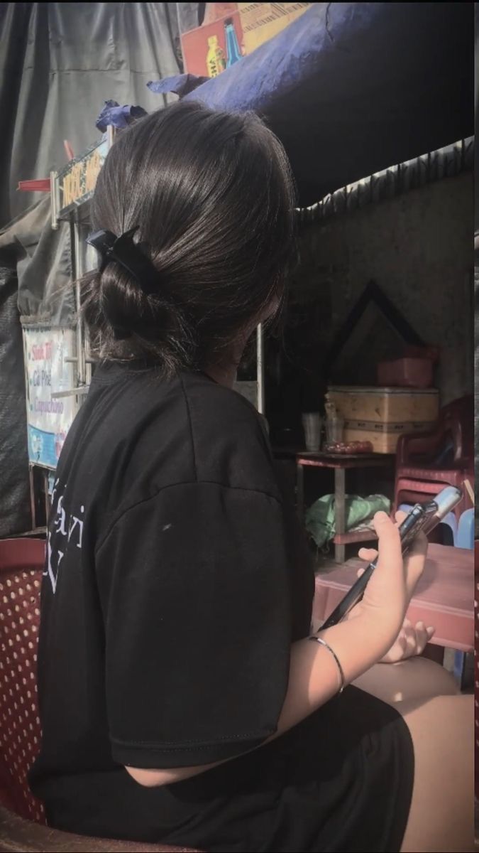 Ảnh gái trẻ mặc áo thun đen ngồi trên ghế bành