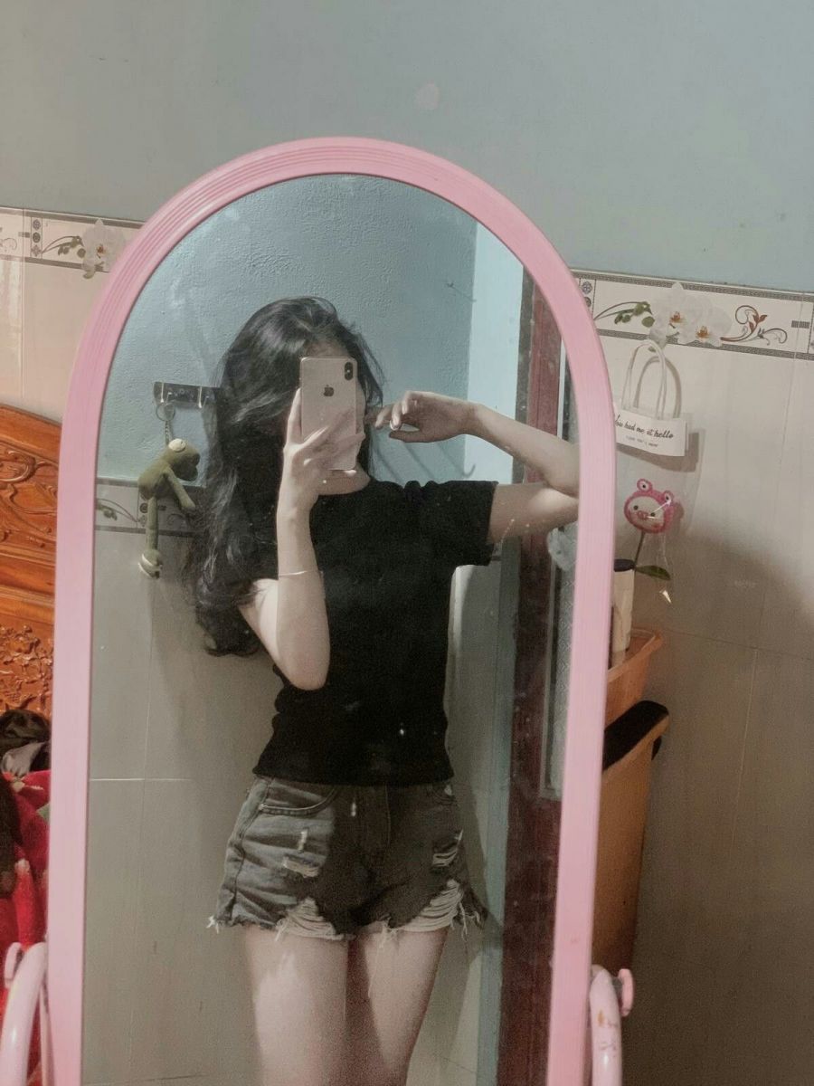 Ảnh gái trẻ mặc áo thun đen và quần short chụp gương trong phòng