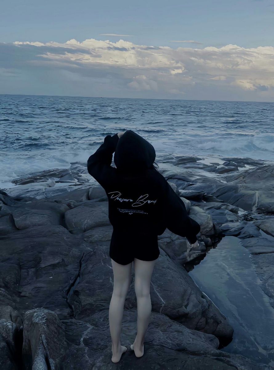 Ảnh gái trẻ mặc hoodie đen trên bãi biển