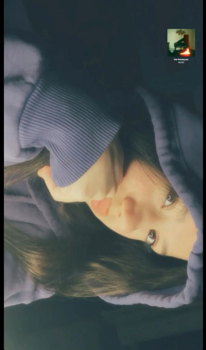 Ảnh gái trẻ mặc hoodie nam nghiêng tay chống cằm trong không gian tối