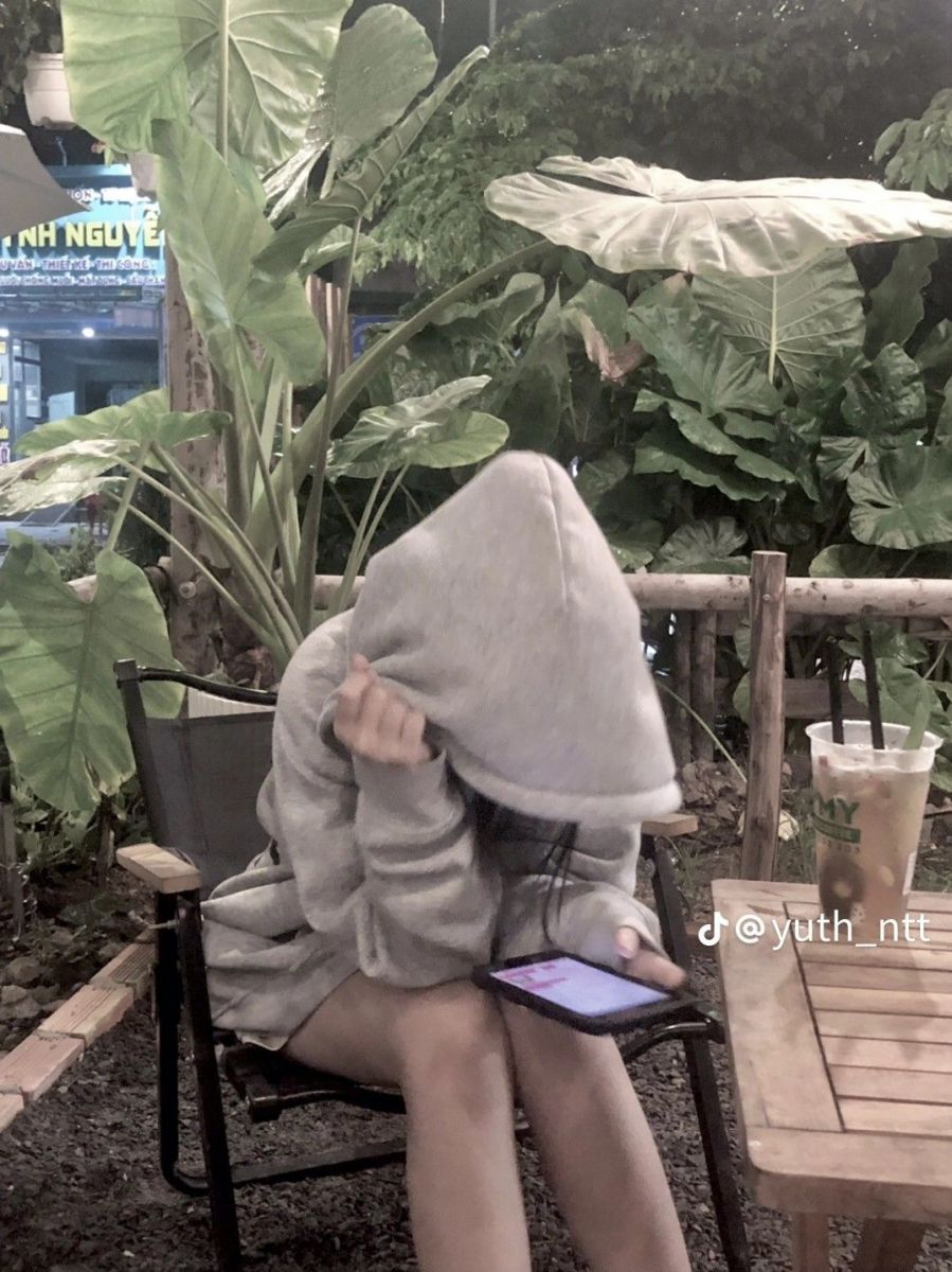 Ảnh gái trẻ mặc hoodie xám ngồi trong quán cà phê