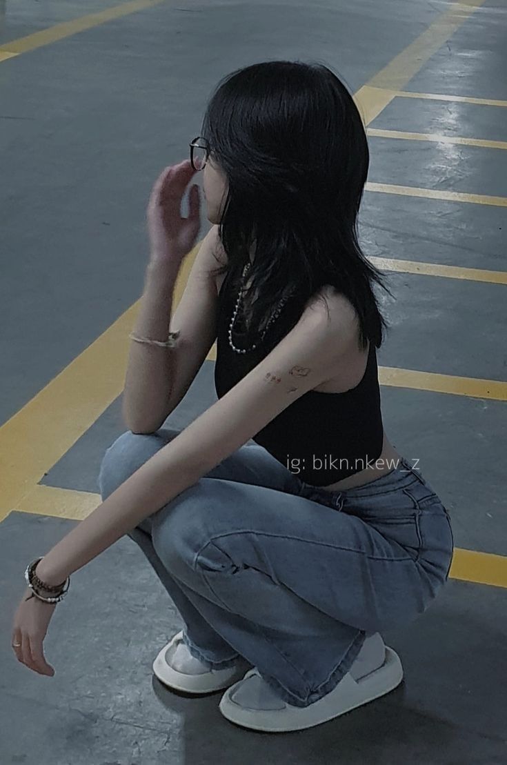 Ảnh gái trẻ với áo tank top và quần jeans rộng tại bãi đỗ xe