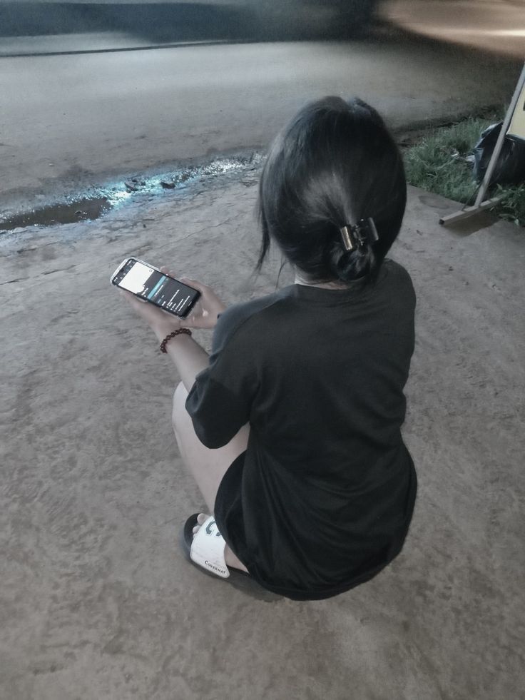 Ảnh gái xinh ngồi trên nền đất mặc áo phông đen
