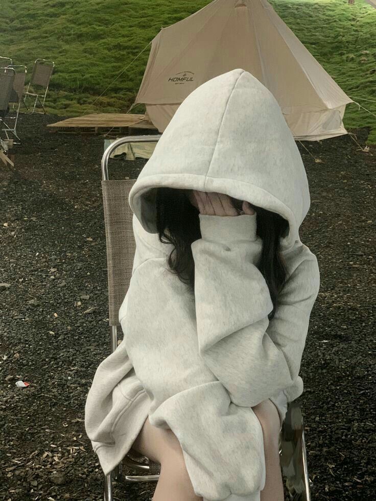 Cô gái mặc áo hoodie xám che mặt đầy bí ẩn