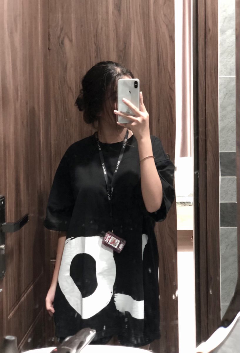 Cô gái mặc áo phông đen tạo dáng chụp ảnh selfie trong gương