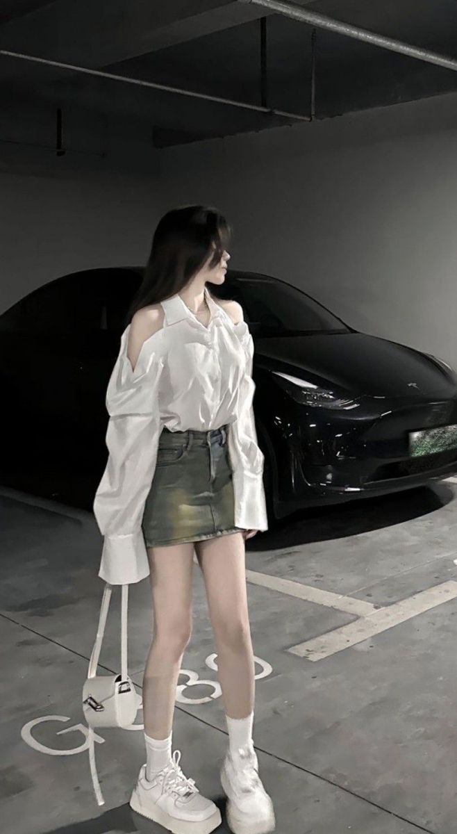 Cô gái mặc áo sơ mi trắng và váy ngắn màu xanh lá