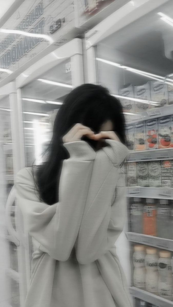 Cô gái nhút nhát trong áo sweater màu sáng che mặt bằng tay