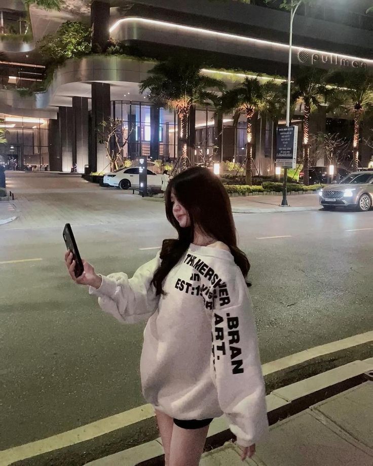 Cô gái trẻ chụp ảnh selfie trên vỉa hè gần khách sạn