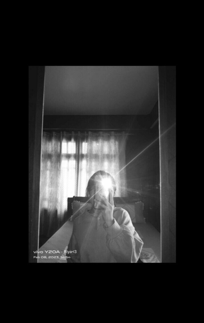 Cô gái trẻ chụp ảnh selfie với áo khoác lớn trong phòng ngủ