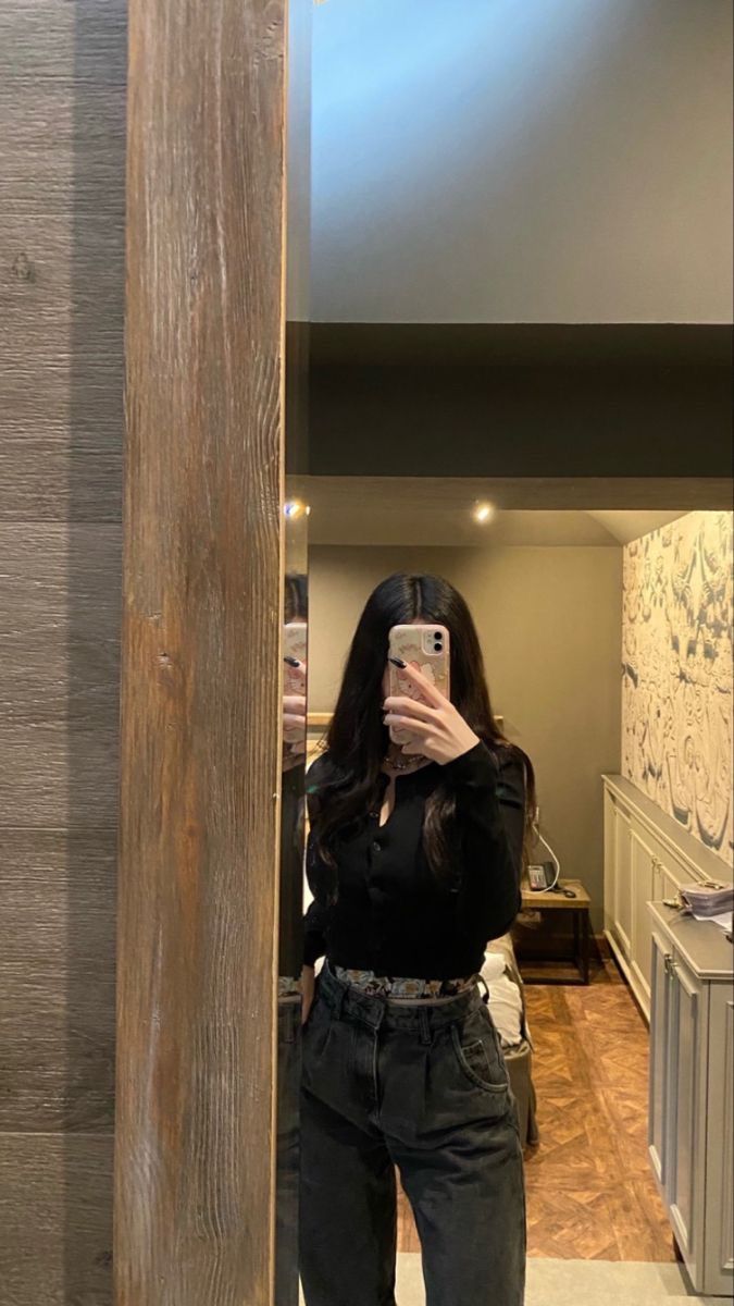 Cô gái trẻ chụp ảnh tự sướng với áo thun đen và quần jeans