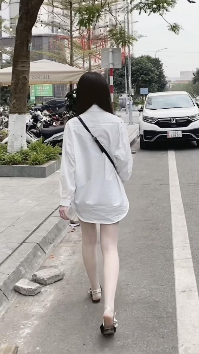 Cô gái trẻ diện áo sơ mi trắng dài đầy tự tin