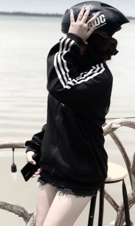 Cô gái trẻ mặc áo hoodie bên bờ nước