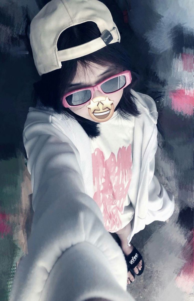 Cô gái trẻ mặc áo hoodie trắng và áo phông in chữ màu hồng