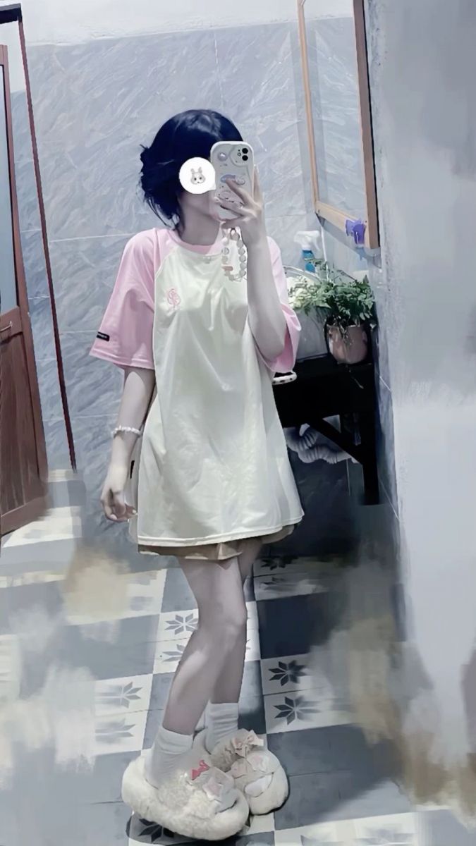 Cô gái trẻ mặc áo phông vàng, hồng chụp ảnh selfie trong gương