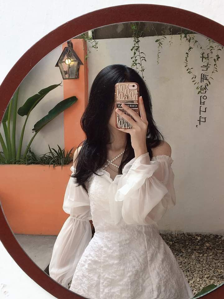 Cô gái trẻ mặc váy trắng xinh đẹp chụp ảnh trong không gian trang trí