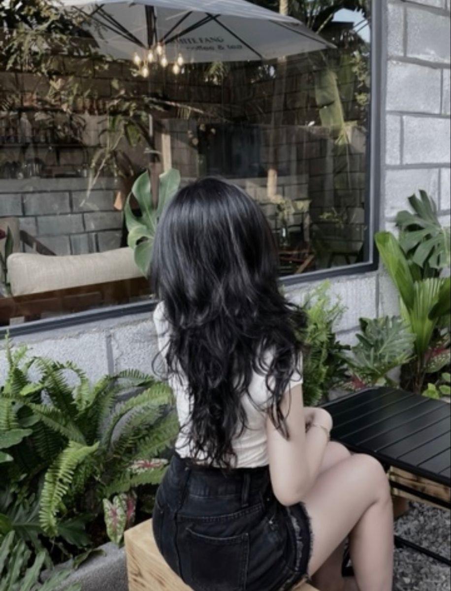 Cô gái trẻ trong áo phông trắng và quần shorts đen