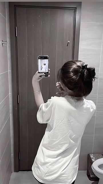 Cô gái trẻ tự tin chụp ảnh selfie với áo thun trắng