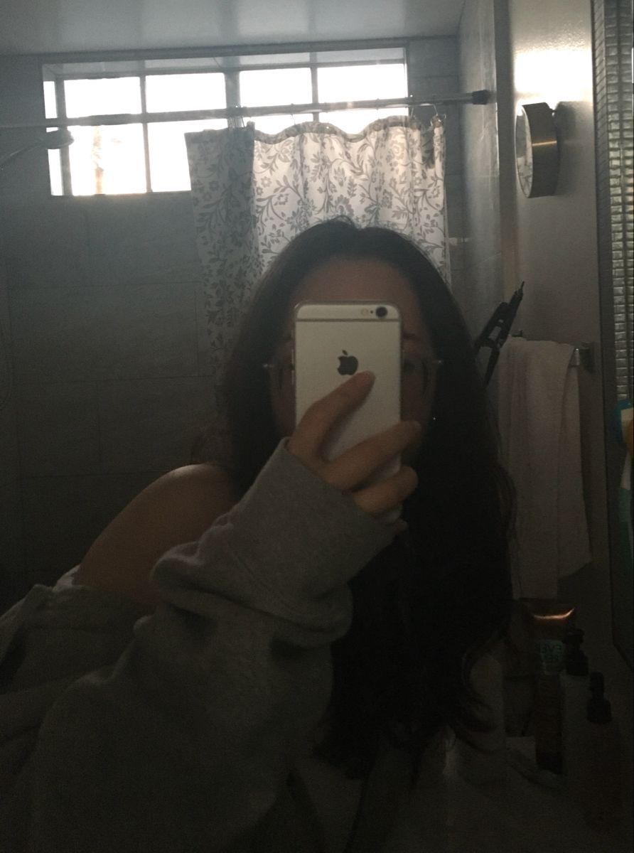 Cô gái trẻ với áo sweatshirt rông chụp ảnh selfie