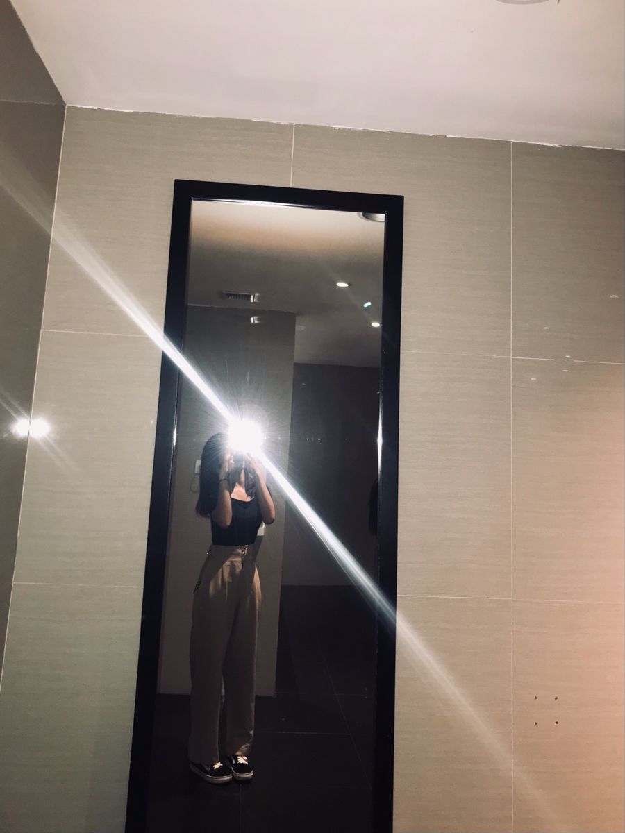 Cô gái trẻ xinh đẹp trong áo crop top đen và quần tây màu be