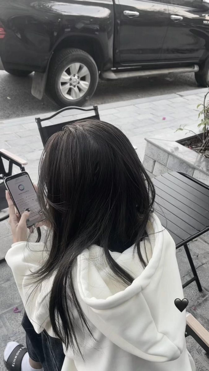 Cô gái trẻ xinh đẹp trong áo hoodie trắng và quần jeans