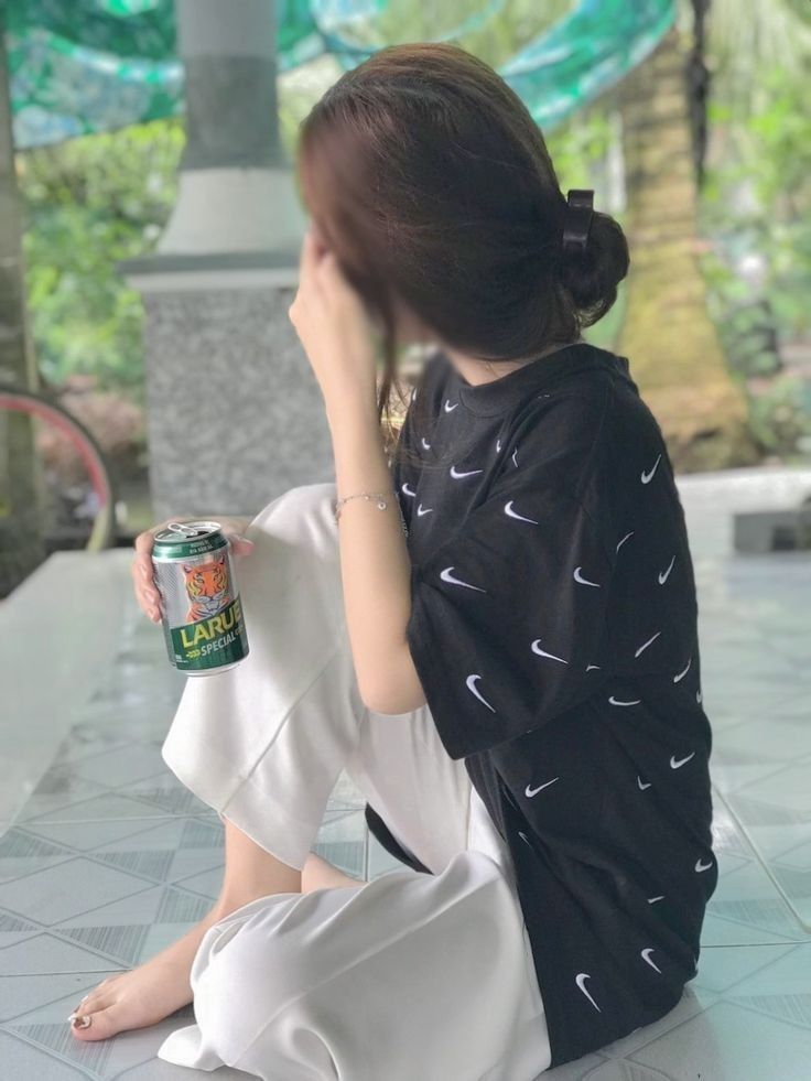 Cô gái trẻ xinh đẹp trong áo thun Nike và quần trắng