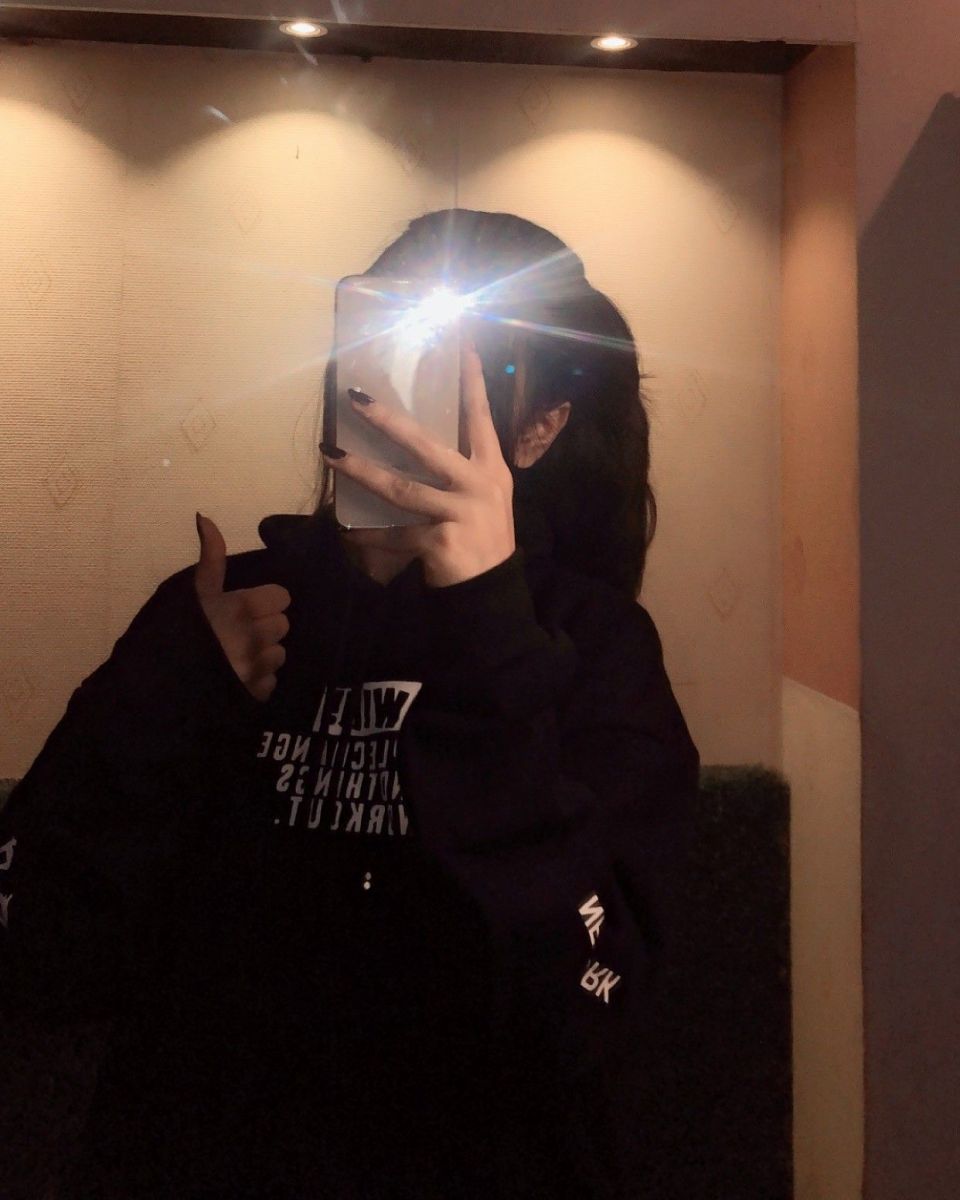Cô gái trẻ xinh đẹp trong chiếc hoodie đen chụp ảnh selfie vui vẻ