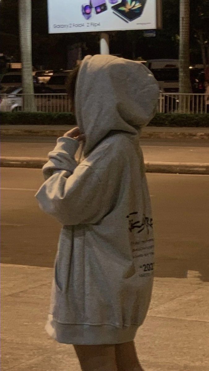 Cô gái trong áo hoodie xám bên đường đêm khuya