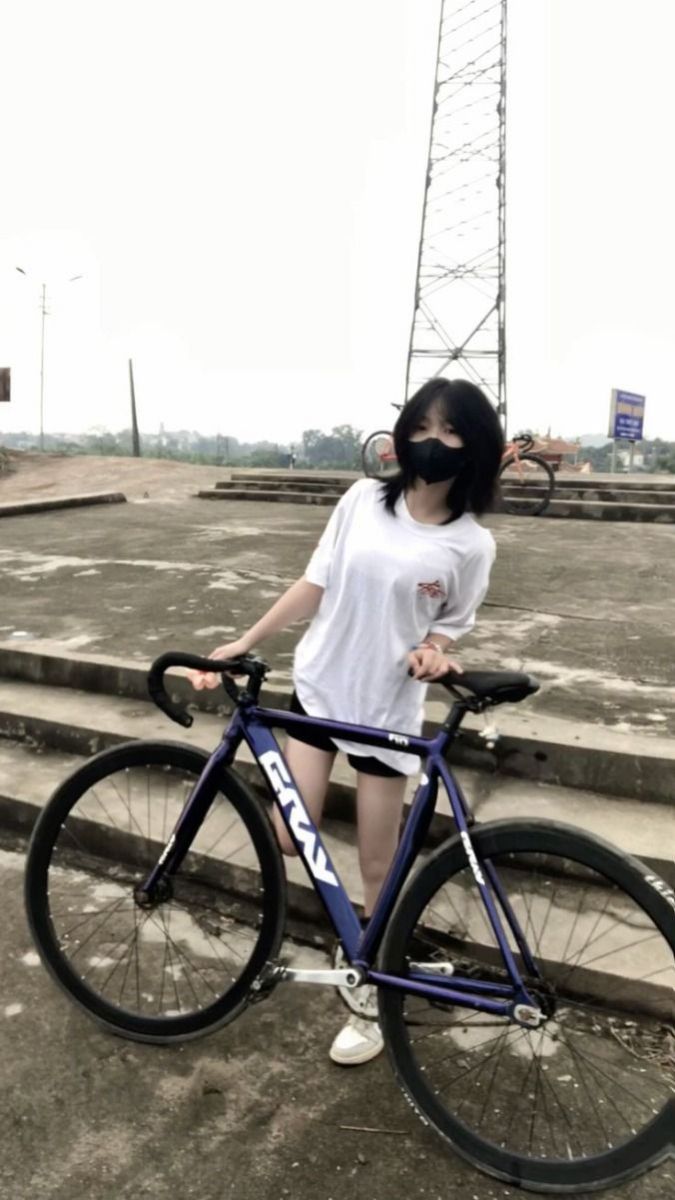 Cô gái xinh đẹp bên xe đạp màu xanh tím