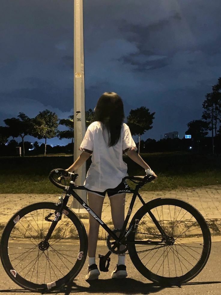 Cô gái xinh đẹp bên xe đạp vào ban đêm