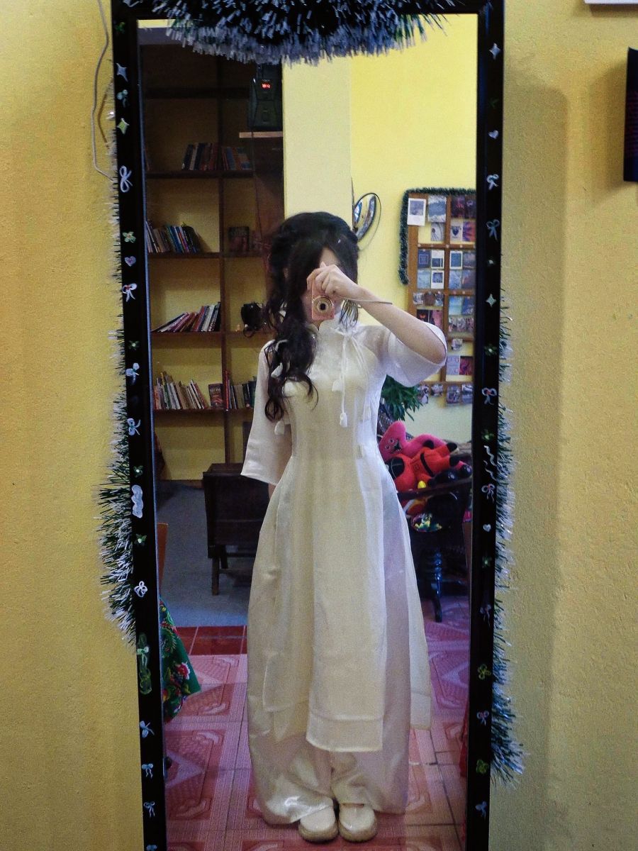 Cô gái xinh đẹp trong áo dài trắng chụp selfie trước gương