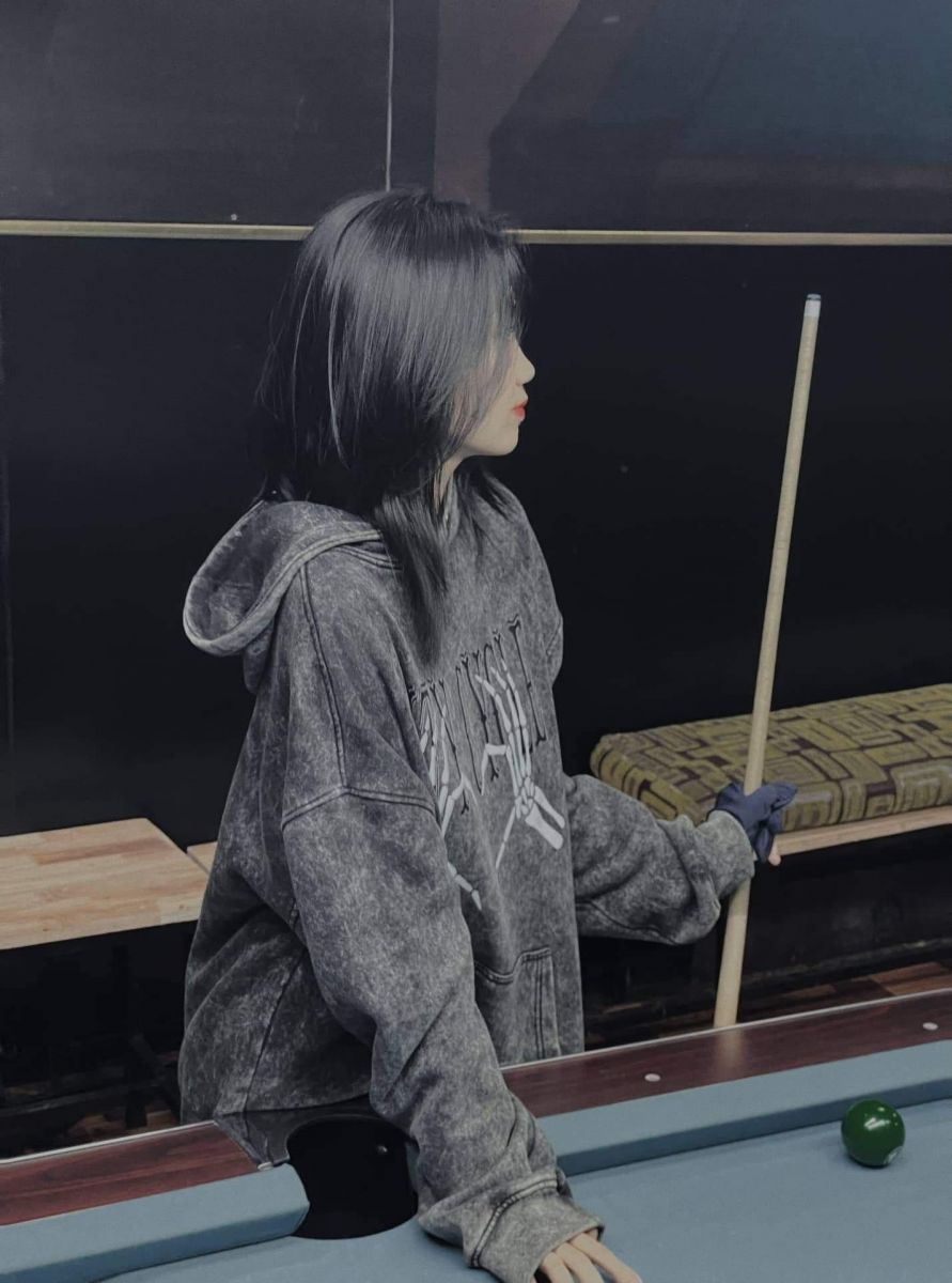 Cô gái xinh đẹp trong áo hoodie xám tại quán bar