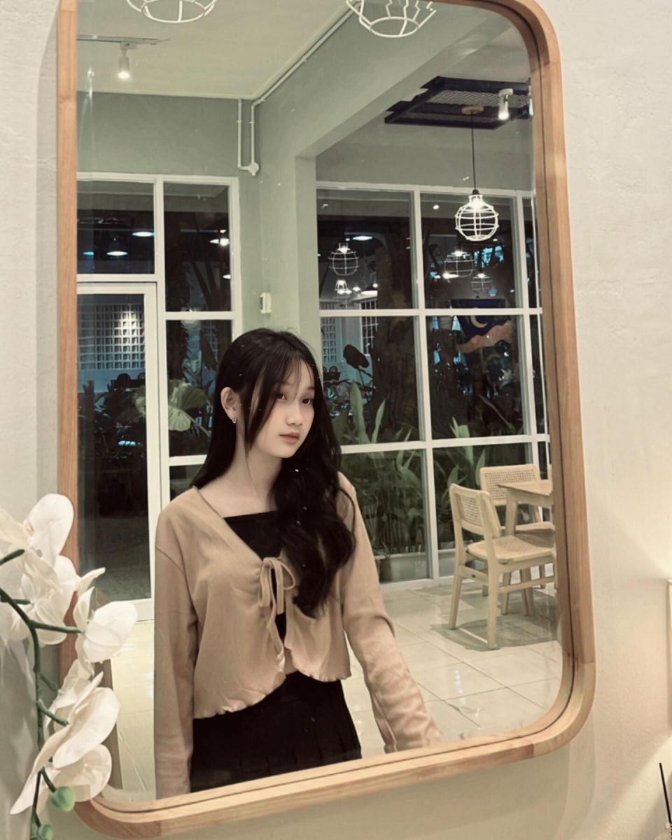 Cô gái xinh đẹp trong áo khoác nhẹ và chân váy đen