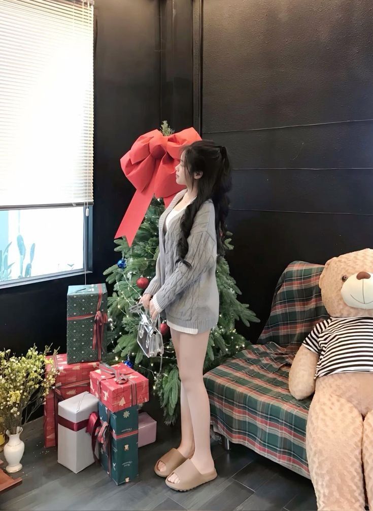 Cô gái xinh đẹp trong áo len xám bên cây thông Noel