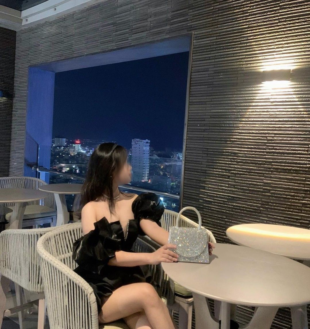 Cô gái xinh đẹp trong bộ đầm đen sáng chói tại quán cà phê Tây