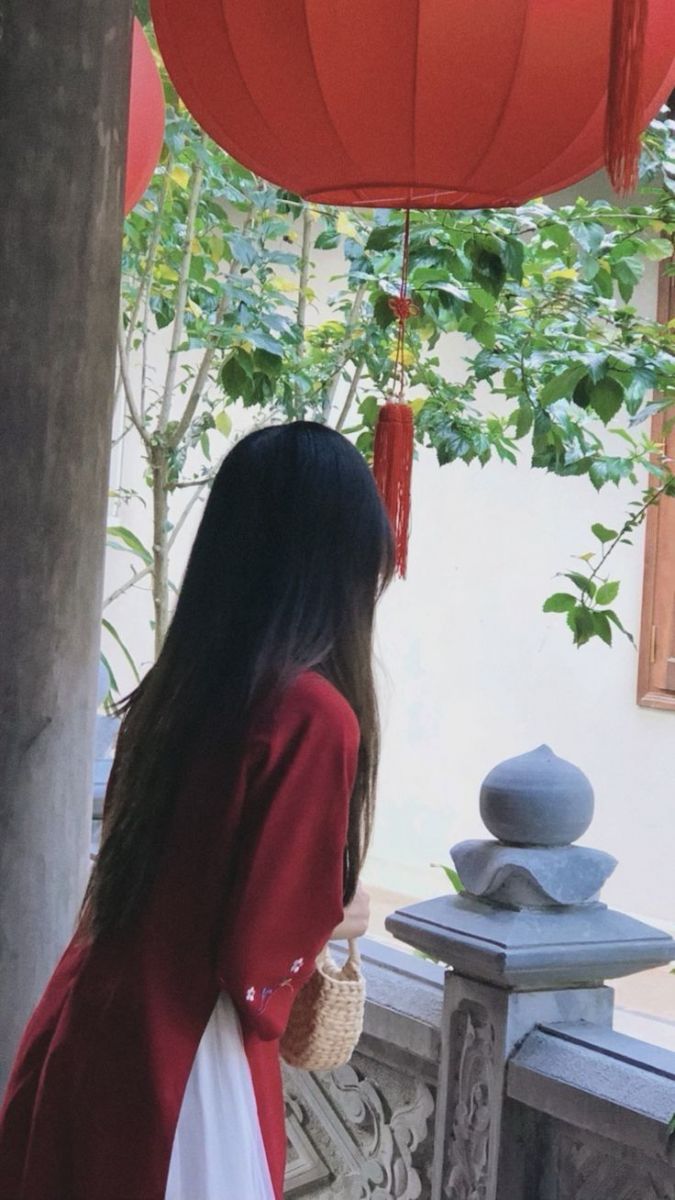 Cô gái xinh đẹp trong tà áo dài đỏ giữa không gian yên bình