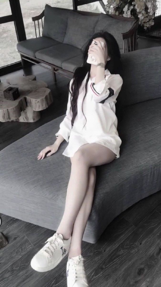Cô gái xinh đẹp với áo sơ mi trắng và giày thể thao
