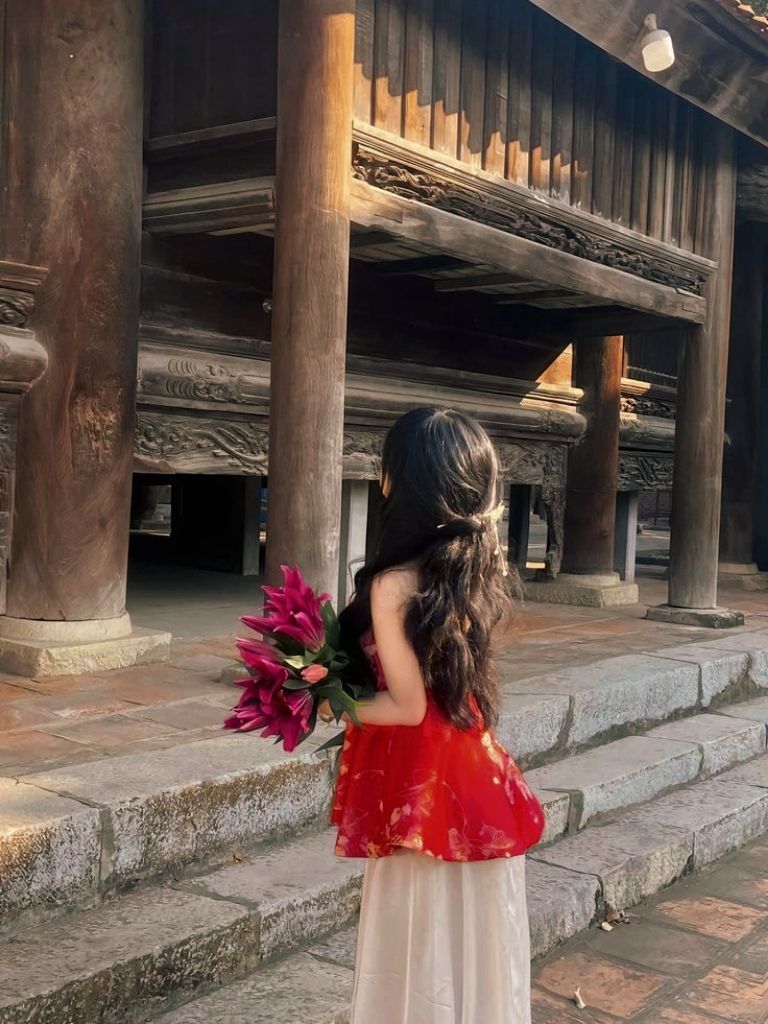 Cô gái xinh mặc áo dài đỏ bên chùa cổ kính