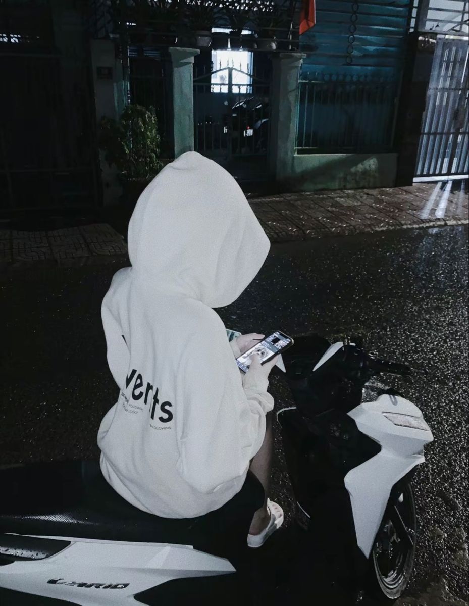 Cô gái xinh mặc áo hoodie trắng ngồi trên xe máy