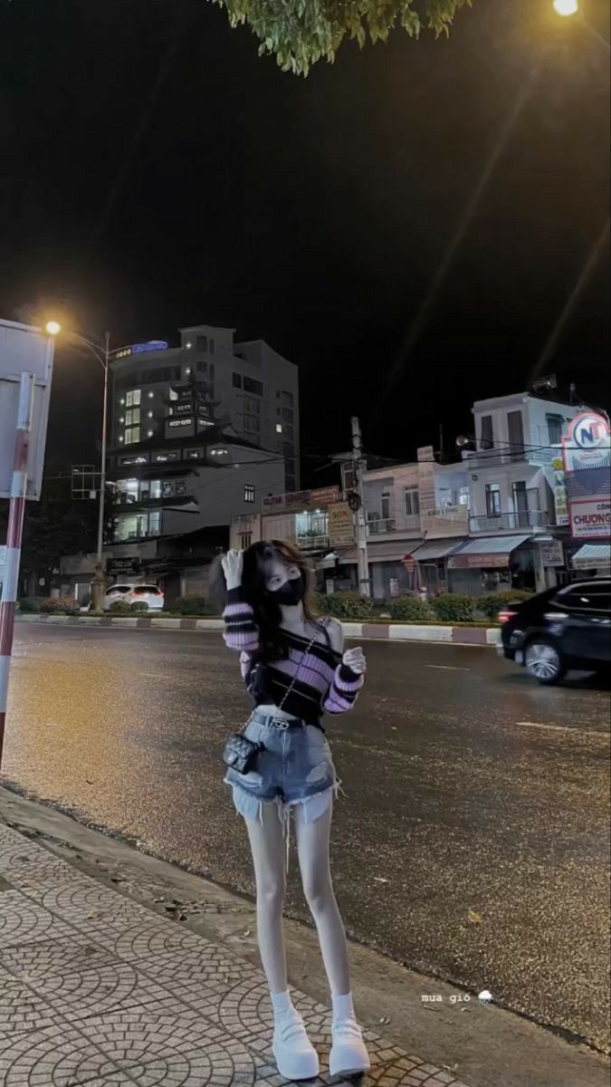 Cô gái xinh mặc áo len sọc tím và quần jeans ngắn đầy phong cách