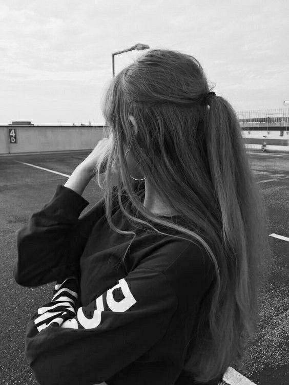 Cô gái xinh mặc áo sweater đen tự tin trên bãi đỗ xe