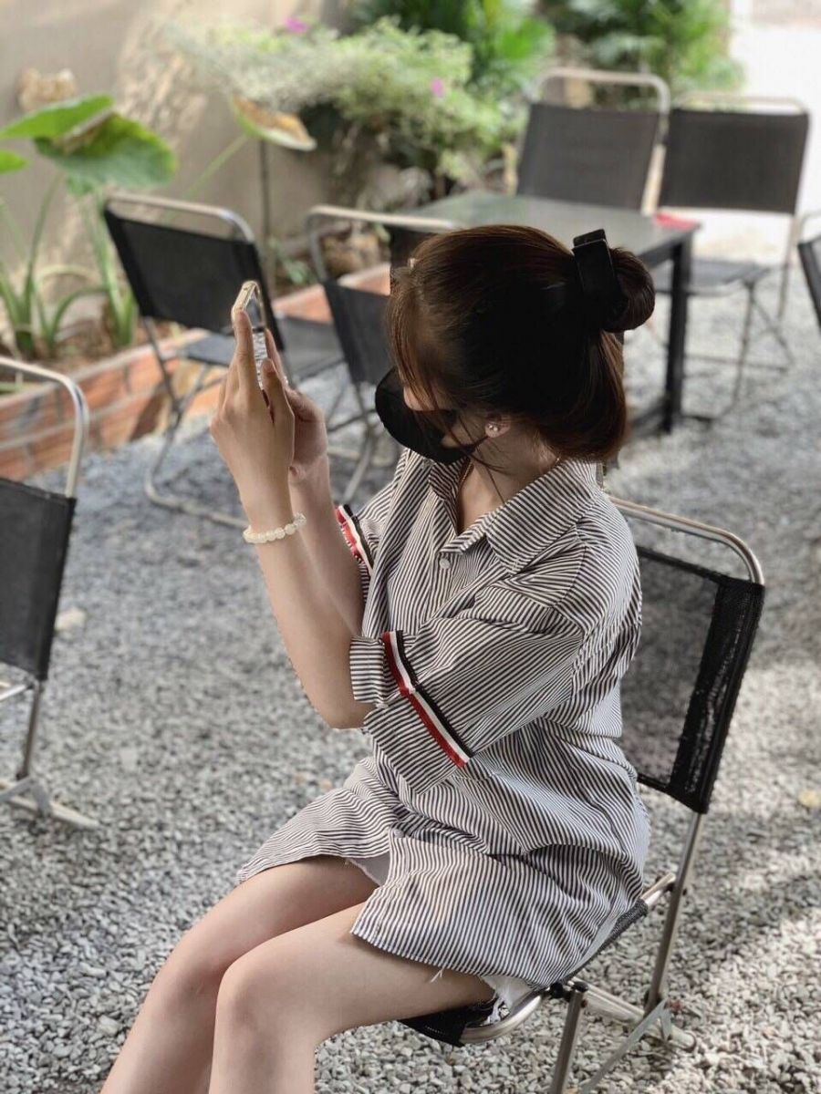 Cô gái xinh mặc áo trong suốt ngồi trên ghế nhựa