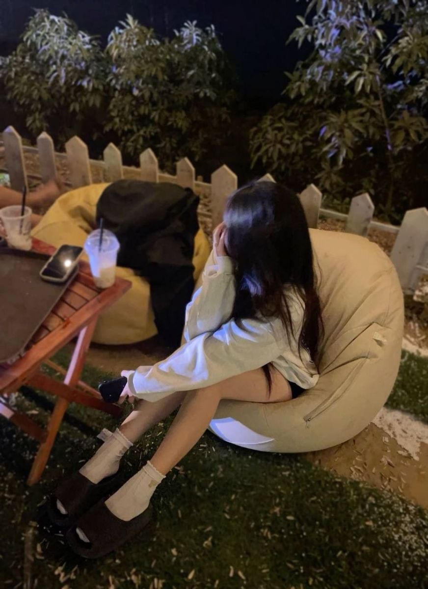 Gái che mặt trong áo hoodie trắng ngồi trên ghế bean bag