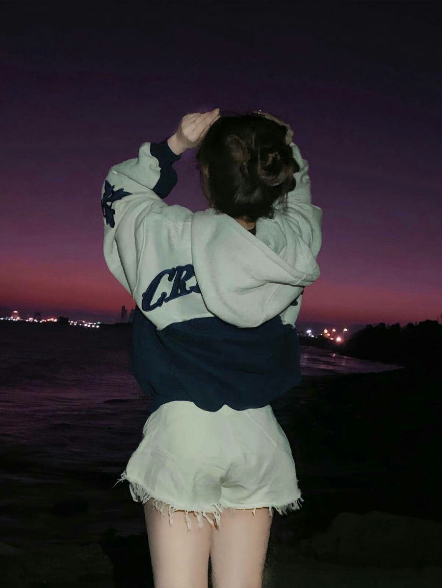 Gái che mặt trong hoodie xám và quần shorts ngắn